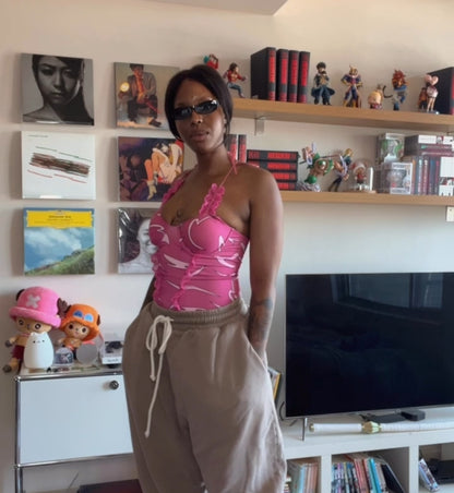 Woman in a pink top and beige pants standing in a room with shelves and books.